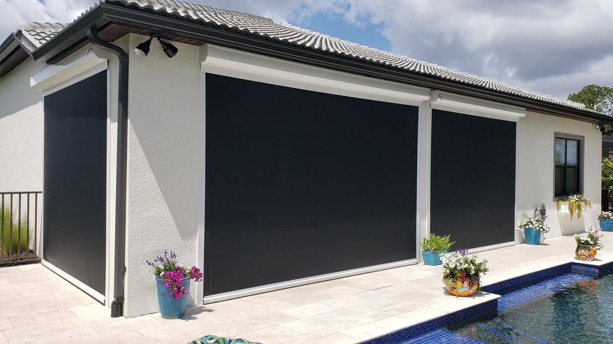 Motorized screens lowered across a white pool house